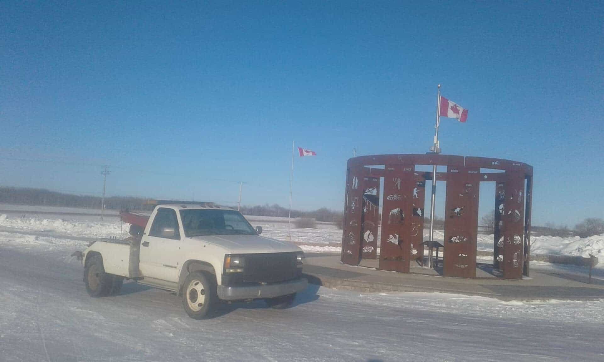 Bro's Tows truck at the Blaine Lake monument with Canadian flags