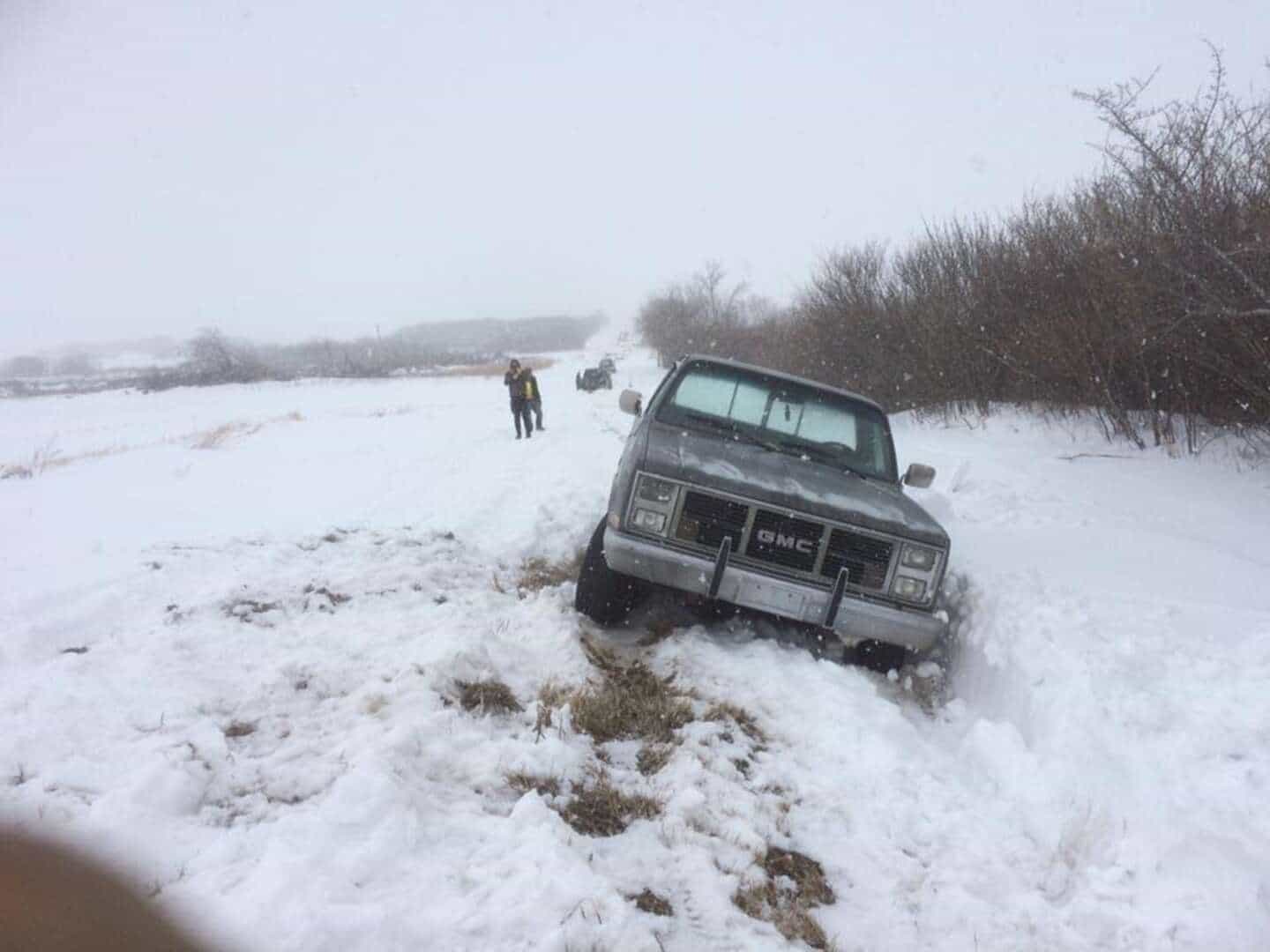 GMC truck stuck in a Saskatchewan snow ditch with Bro's Tows crew recovering it
