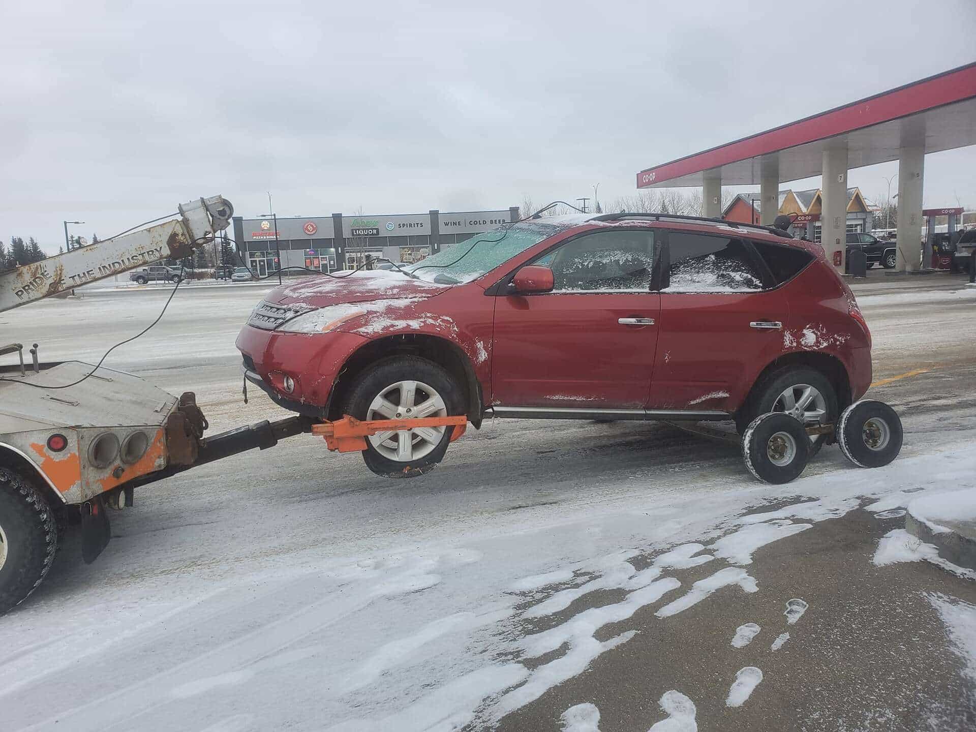Bro's Tows towing a red SUV through Saskatoon winter snow